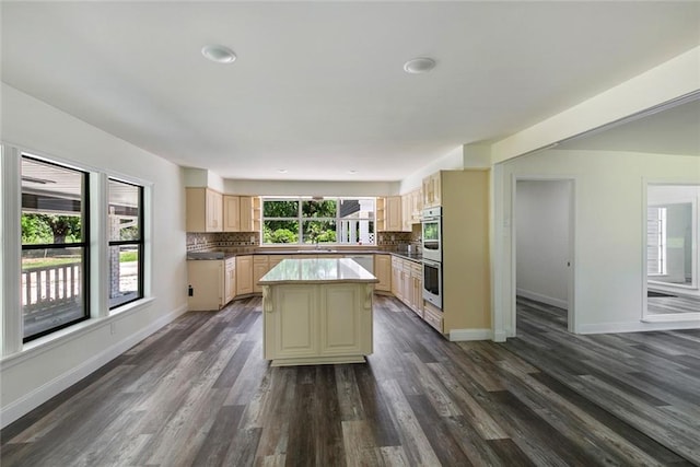 60078 W Park Cir, Lacombe, LA 70445 - kitchen featuring stainless steel double oven, dark wood-style floors, decorative backsplash, a kitchen island, and baseboards