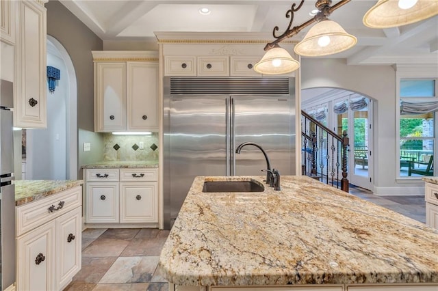 11 Arbor Cir, New Orleans, LA 70131 - kitchen with arched walkways, light stone counters, a sink, stone tile flooring, and coffered ceiling