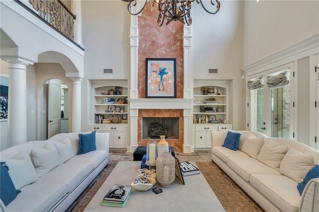 11 Arbor Cir, New Orleans, LA 70131 - living room with a high ceiling, arched walkways, built in features, decorative columns, and a fireplace