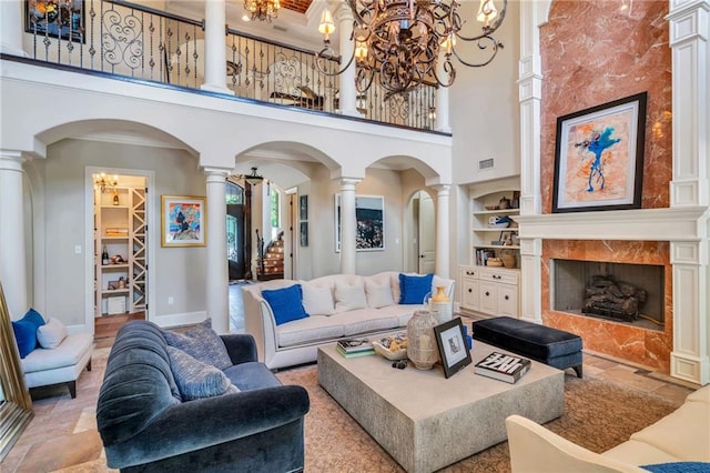 11 Arbor Cir, New Orleans, LA 70131 - living area with ornate columns, arched walkways, a towering ceiling, a chandelier, and built in shelves