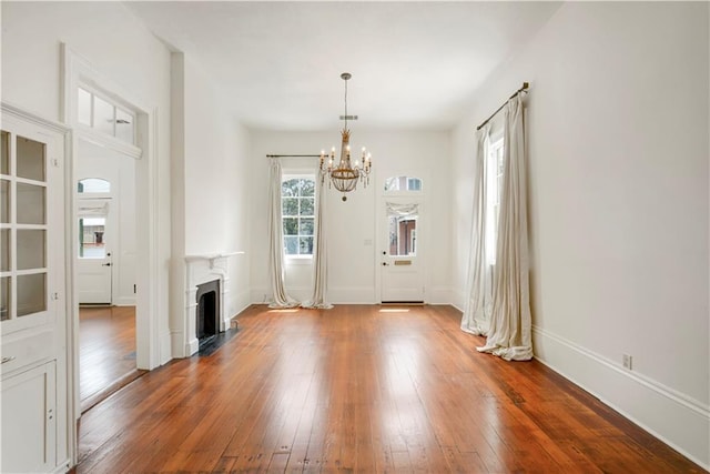 912 Spain St, New Orleans, LA 70117 - unfurnished living room featuring a chandelier, hardwood / wood-style floors, baseboards, and a fireplace with flush hearth