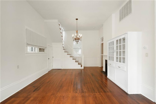 912 Spain St, New Orleans, LA 70117 - entryway with a chandelier, wood-type flooring, stairway, baseboards, and a fireplace