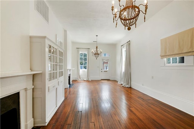 912 Spain St, New Orleans, LA 70117 - unfurnished living room with a chandelier, a fireplace, dark wood finished floors, and baseboards