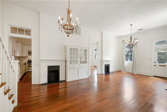 912 Spain St, New Orleans, LA 70117 - unfurnished living room with a fireplace with flush hearth, a chandelier, and dark wood finished floors