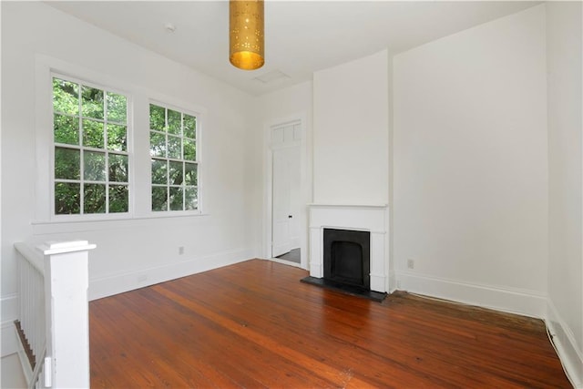 912 Spain St, New Orleans, LA 70117 - unfurnished living room with wood finished floors, baseboards, and a fireplace with raised hearth
