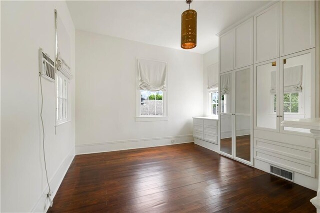 912 Spain St, New Orleans, LA 70117 - unfurnished bedroom featuring multiple windows, dark wood-style flooring, and baseboards