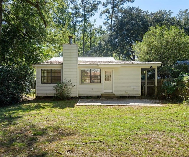 718 E 10th Ave, Covington, LA 70433 - rear view of house featuring a chimney, a patio area, entry steps, and metal roof