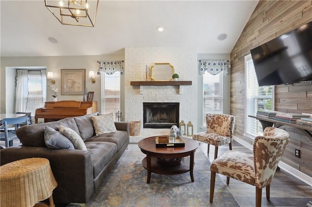 living room with vaulted ceiling, healthy amount of natural light, a fireplace, and wood finished floors