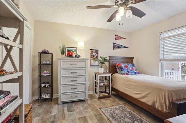 bedroom featuring wood finished floors, baseboards, and ceiling fan