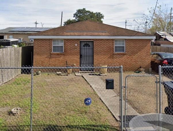 3855 Metropolitan St, New Orleans, LA 70126 - bungalow-style home with brick siding, a gate, and roof with shingles