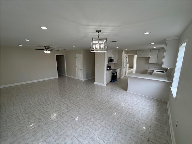 564 Oakwood Dr, Gretna, LA 70056 - unfurnished living room with recessed lighting, baseboards, ceiling fan, a chandelier, and a sink
