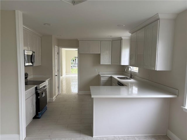 564 Oakwood Dr, Gretna, LA 70056 - kitchen with electric stove, a sink, stainless steel microwave, a peninsula, and light countertops