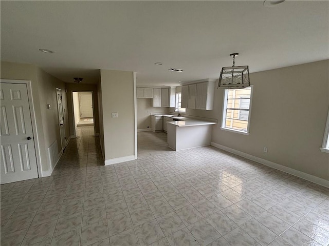 564 Oakwood Dr, Gretna, LA 70056 - kitchen featuring a sink, light countertops, baseboards, open floor plan, and hanging light fixtures