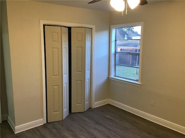 564 Oakwood Dr, Gretna, LA 70056 - unfurnished bedroom featuring dark wood-style flooring, baseboards, a closet, and a ceiling fan