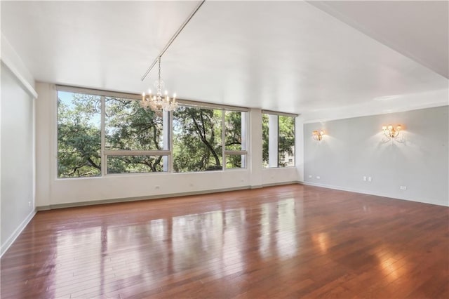 2100 Saint Charles Ave Unit 4D, New Orleans, LA 70130 - unfurnished room featuring plenty of natural light, a chandelier, wood-type flooring, and baseboards
