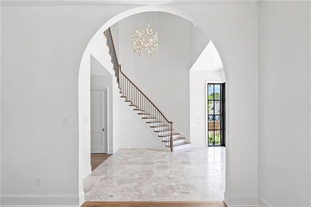 136 Linnette Ln, Mandeville, LA 70471 - foyer entrance with arched walkways, stairs, a chandelier, and baseboards