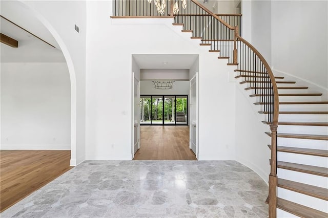 136 Linnette Ln, Mandeville, LA 70471 - entryway featuring a towering ceiling, arched walkways, stairs, wood finished floors, and baseboards