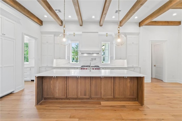 136 Linnette Ln, Mandeville, LA 70471 - kitchen featuring light countertops, healthy amount of natural light, decorative backsplash, white cabinets, and beam ceiling