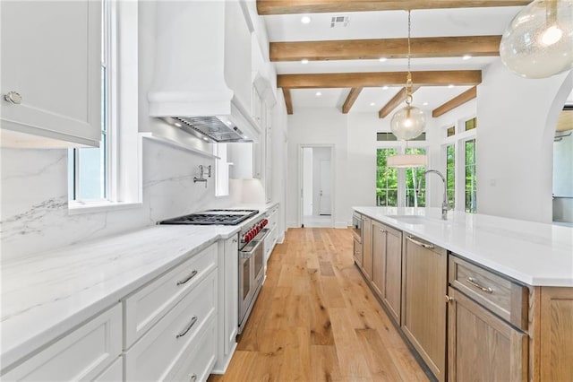 136 Linnette Ln, Mandeville, LA 70471 - kitchen with high end range, premium range hood, plenty of natural light, a sink, and beam ceiling