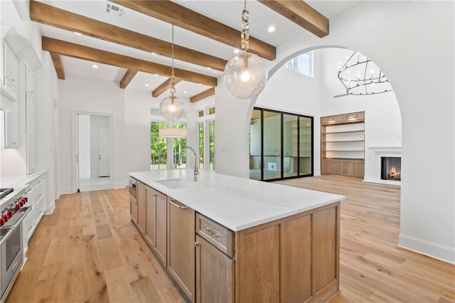 136 Linnette Ln, Mandeville, LA 70471 - kitchen with a sink, light wood-style floors, a chandelier, decorative light fixtures, and beam ceiling