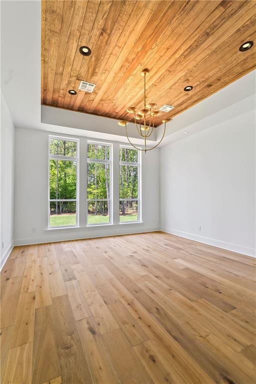 136 Linnette Ln, Mandeville, LA 70471 - empty room featuring wood ceiling, healthy amount of natural light, a chandelier, light wood-type flooring, and baseboards