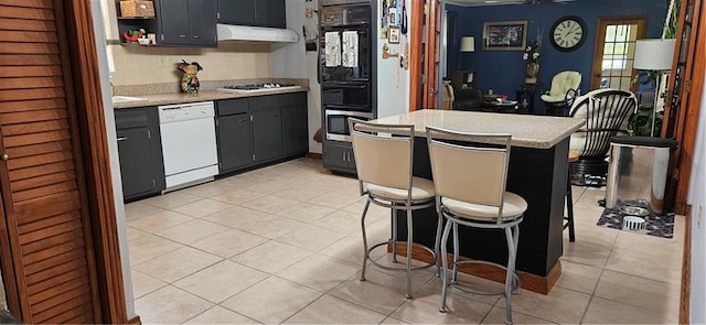 3231 47th St, Metairie, LA 70001 - kitchen featuring white appliances, light countertops, under cabinet range hood, light tile patterned floors, and open shelves