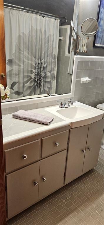 3231 47th St, Metairie, LA 70001 - bathroom featuring vanity, brick patterned flooring, tile walls, and a shower with curtain