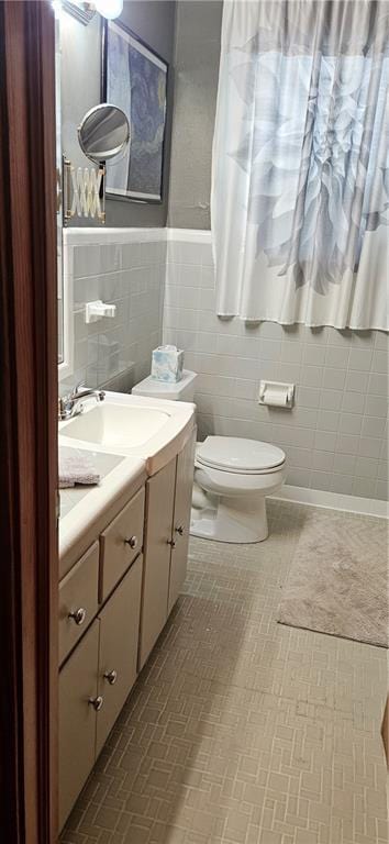 3231 47th St, Metairie, LA 70001 - half bath featuring toilet, tile walls, vanity, and a wainscoted wall