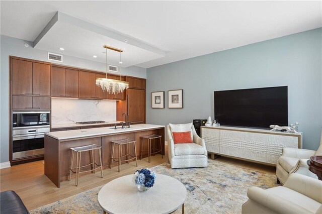 living room with light wood-style flooring, a chandelier, and recessed lighting