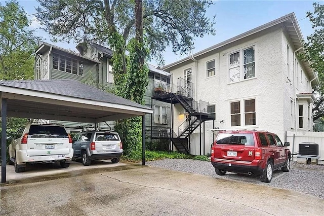 8-10 Neron Pl, New Orleans, LA 70118 - view of front of house featuring stairway, stucco siding, and concrete driveway