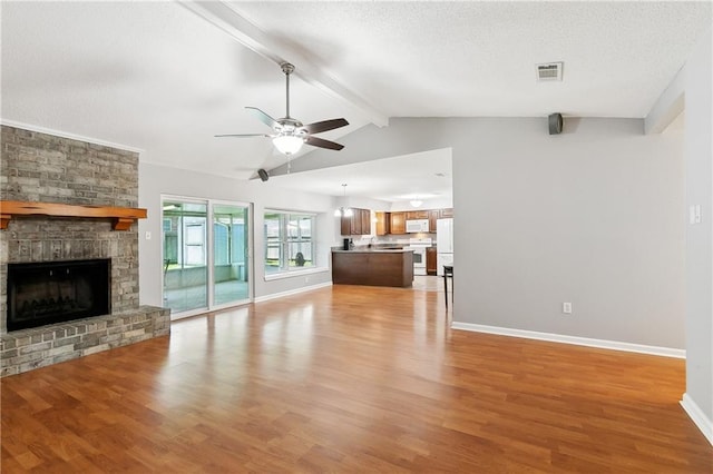 2701 Chenier St, Marrero, LA 70072 - unfurnished living room featuring ceiling fan, light wood-type flooring, a fireplace, baseboards, and a textured ceiling