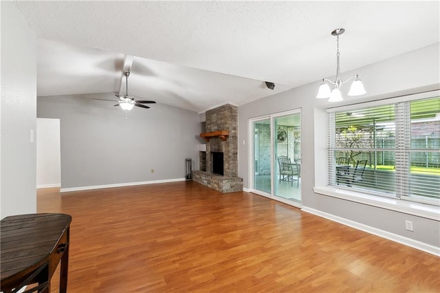 2701 Chenier St, Marrero, LA 70072 - unfurnished living room with a chandelier, light wood finished floors, lofted ceiling, ceiling fan, and a fireplace