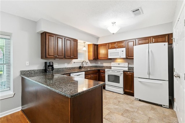 2701 Chenier St, Marrero, LA 70072 - kitchen with white appliances, a sink, a peninsula, dark stone countertops, and a textured ceiling