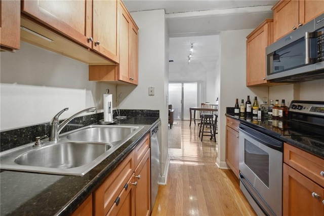 760 Magazine St Unit 113, New Orleans, LA 70130 - kitchen with stainless steel appliances, a sink, light wood finished floors, and brown cabinetry