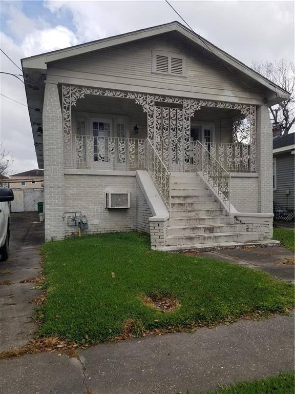 11921 Hesper Ave, Metairie, LA 70005 - view of front facade with stairway, brick siding, a porch, and a front lawn