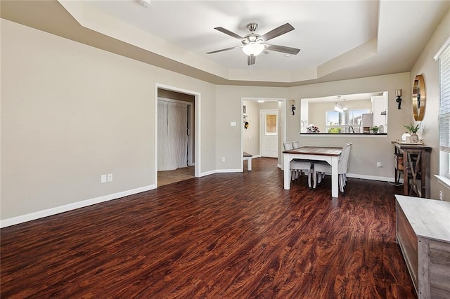5926 Tullis Dr, New Orleans, LA 70131 - dining area with a tray ceiling, a ceiling fan, wood finished floors, baseboards, and a chandelier