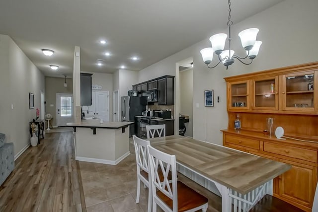 dining room with a chandelier, baseboards, recessed lighting, and light tile patterned floors