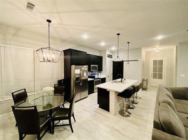 1758 Mary Dr, Slidell, LA 70458 - kitchen with stainless steel appliances, dark cabinets, a sink, open floor plan, and a kitchen breakfast bar