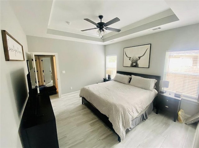 1758 Mary Dr, Slidell, LA 70458 - bedroom with a raised ceiling, baseboards, ceiling fan, and light wood-type flooring