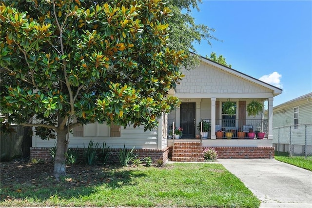 5517 N Rampart St, New Orleans, LA 70117 - view of front facade with a porch and a front lawn