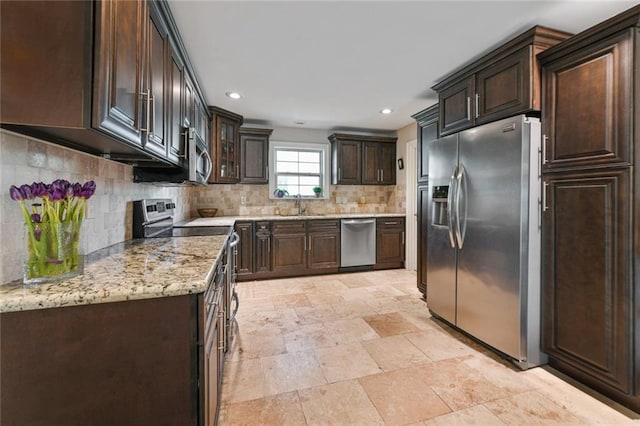 5517 N Rampart St, New Orleans, LA 70117 - kitchen with appliances with stainless steel finishes, dark brown cabinets, a sink, backsplash, and light stone finish floors