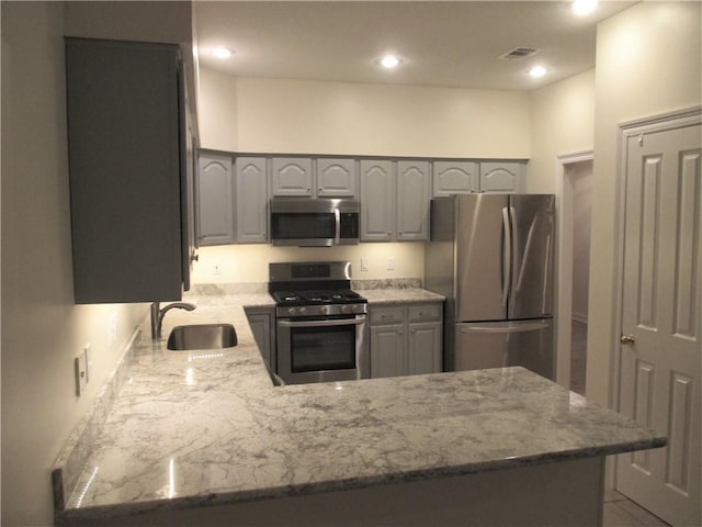 57 Elizabeth Ct, Mandeville, LA 70448 - kitchen featuring stainless steel appliances, a sink, gray cabinets, a peninsula, and recessed lighting