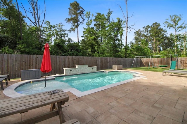 view of pool with a patio, a playground, and a fenced backyard