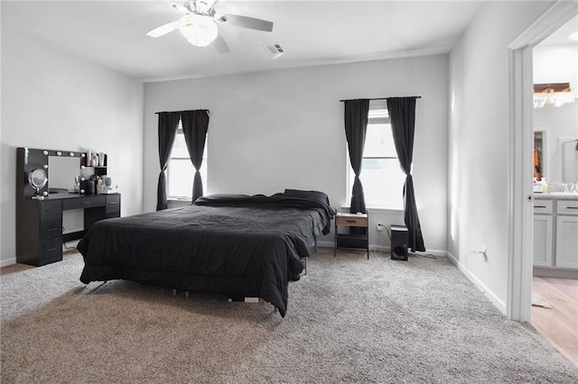 bedroom with carpet flooring, a ceiling fan, baseboards, and ensuite bath