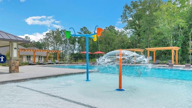community pool featuring a water play area, a pergola, and a patio