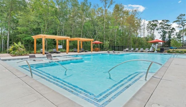 community pool featuring fence and a patio