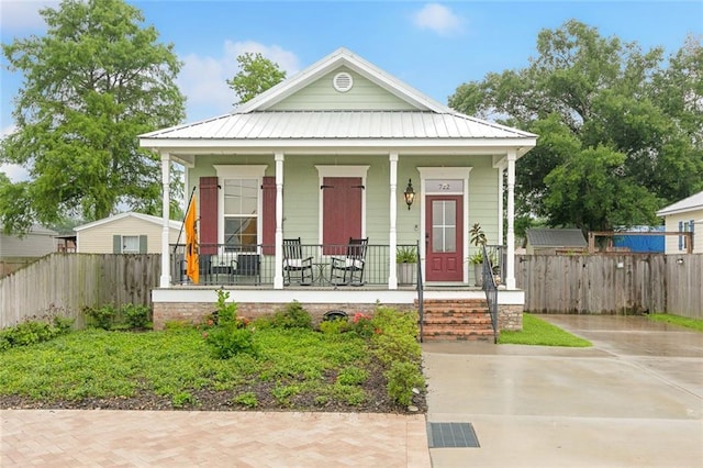 722 Luling Ave, Luling, LA 70070 - shotgun-style home with a porch, fence, metal roof, and driveway