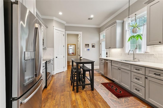 722 Luling Ave, Luling, LA 70070 - kitchen featuring stainless steel appliances, gray cabinets, a sink, decorative backsplash, and light countertops