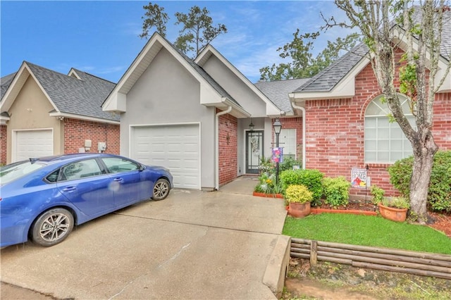 270 Libra Ave Unit B, Mandeville, LA 70471 - view of front facade featuring a garage, concrete driveway, brick siding, a shingled roof, and stucco siding