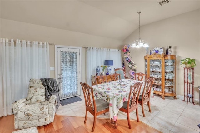 270 Libra Ave Unit B, Mandeville, LA 70471 - dining room featuring a chandelier, lofted ceiling, light tile patterned floors, and baseboards